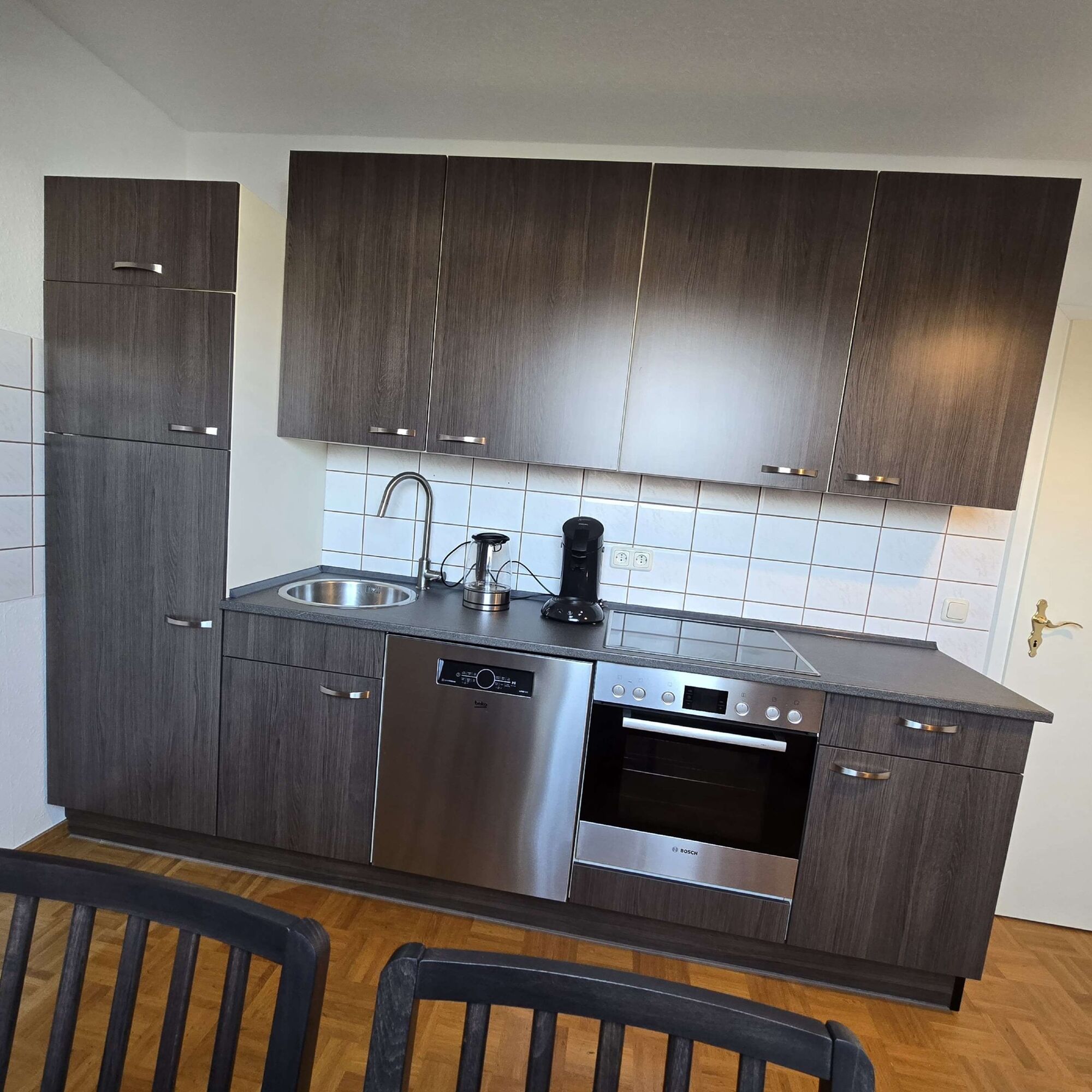 Voll ausgestattete Küche mit Backofen, Kochfeld, Geschirrspüler, Kühlschrank und Kaffeemaschine. Voll ausgestattete Küche mit Backofen, Kochfeld, Geschirrspüler, Kühlschrank und Kaffeemaschine.