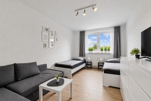 Helles Schlafzimmer mit gemütlichem Sofa für zusätzlichen Komfort und Entspannung. Helles Schlafzimmer mit gemütlichem Sofa für zusätzlichen Komfort und Entspannung.