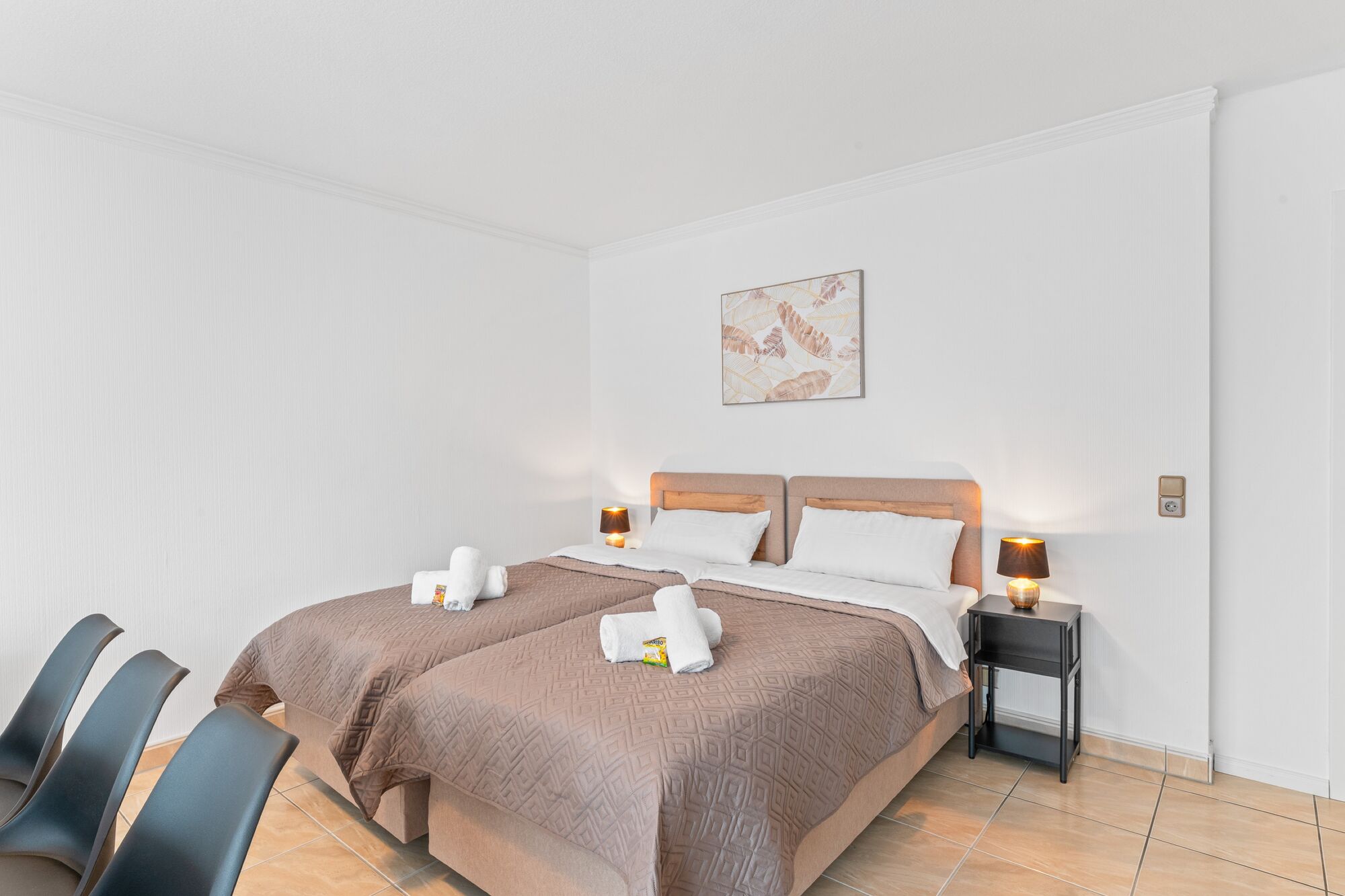 Wohnzimmer mit zwei hochwertigen Boxspringbetten und einem gemütlichen Essbereich. Die Betten können wahlweise einzeln oder als komfortables Doppelbett gestellt werden. Wohnzimmer mit zwei hochwertigen Boxspringbetten und einem gemütlichen Essbereich. Die Betten können wahlweise einzeln oder als komfortables Doppelbett gestellt werden.