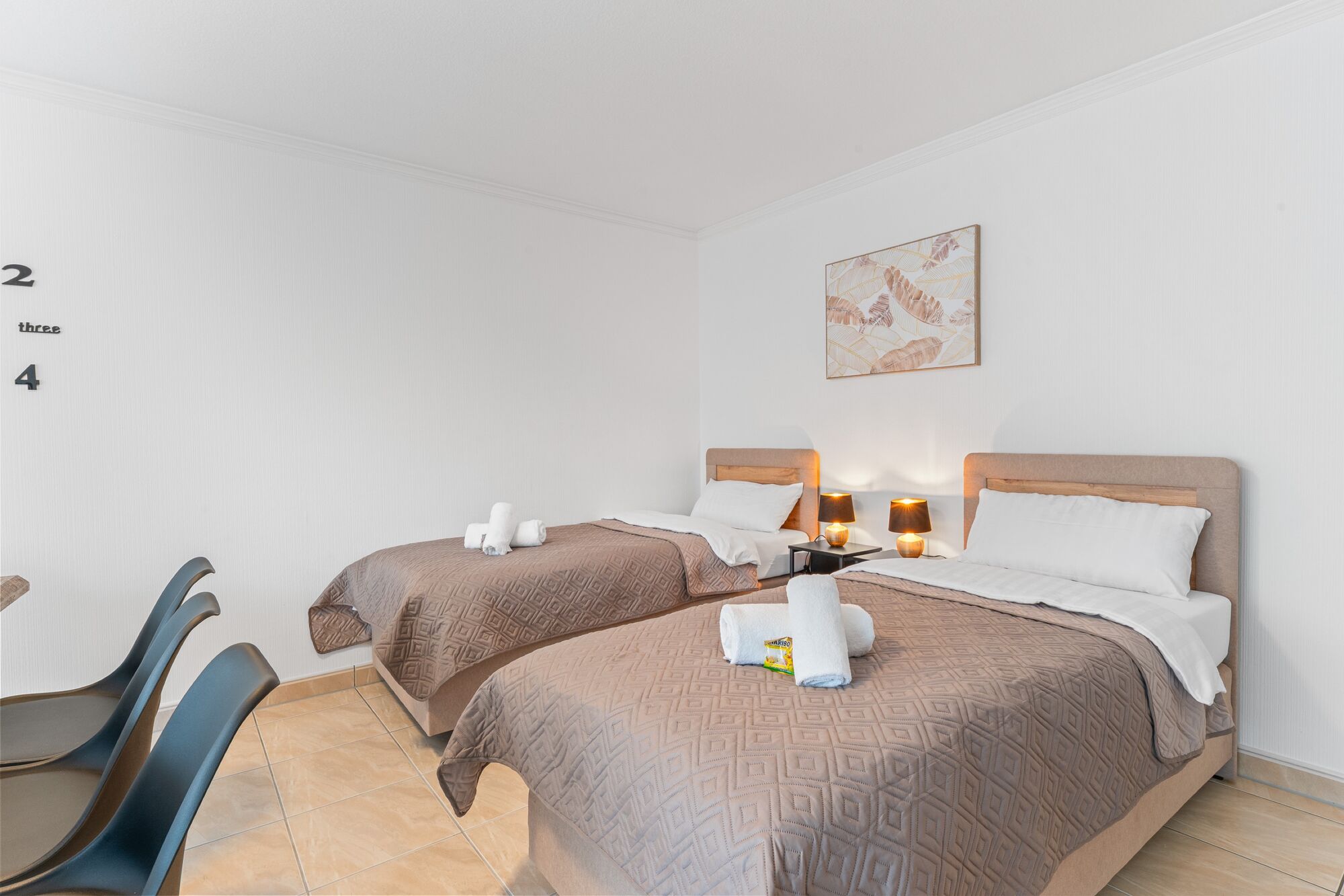 Wohnzimmer mit zwei hochwertigen Boxspringbetten und einem gemütlichen Essbereich. Die Betten können wahlweise einzeln oder als komfortables Doppelbett gestellt werden. Wohnzimmer mit zwei hochwertigen Boxspringbetten und einem gemütlichen Essbereich. Die Betten können wahlweise einzeln oder als komfortables Doppelbett gestellt werden.