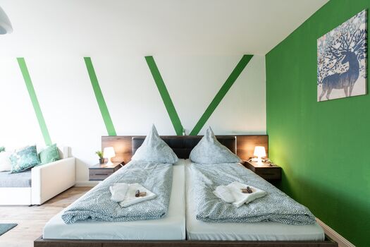 Helles Schlafzimmer mit komfortablem Bett, Sitzecke und modernem Design – ideal für lange Aufenthalte. #VonVImmoServiceUG #Schlafzimmer #KomfortabelWohnen #Lichtdurchflutet #Entspannen #Duisburg