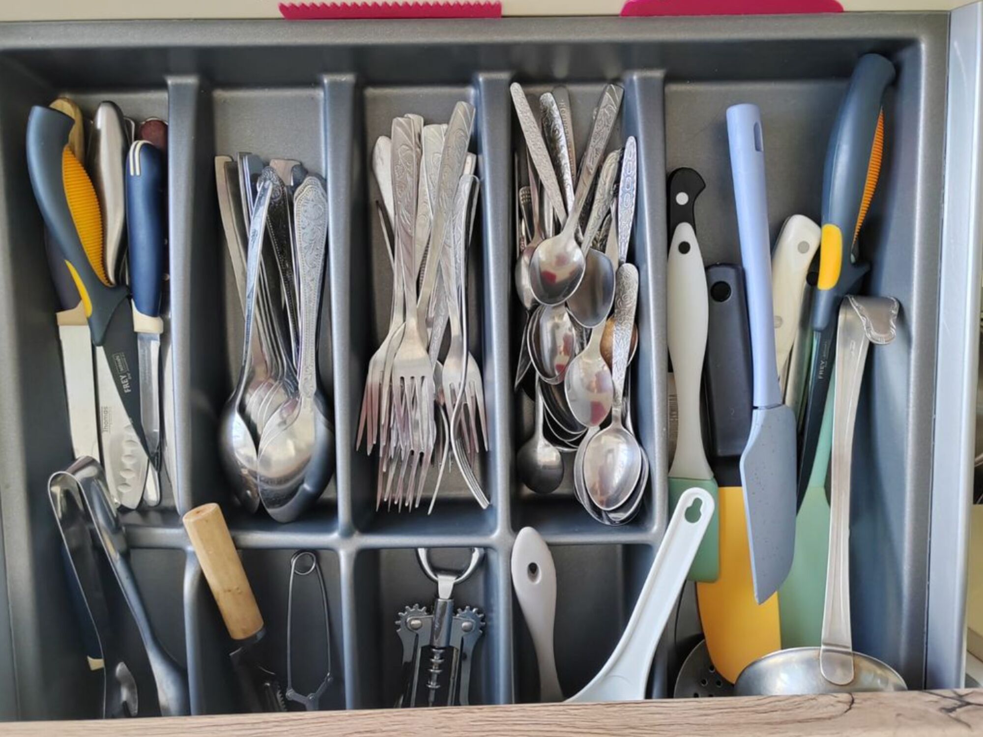 Praktisch sortierte Besteckschublade mit Löffeln, Gabeln, Messern, Korkenzieher und Kochwerkzeugen – alles griffbereit für den täglichen Gebrauch. #BesteckSchublade #KücheDuisburg #VollAusgestattet #VonVImmoServiceUG #Langzeitaufenthalt #Kochutensilien #OrdnungInDerKüche