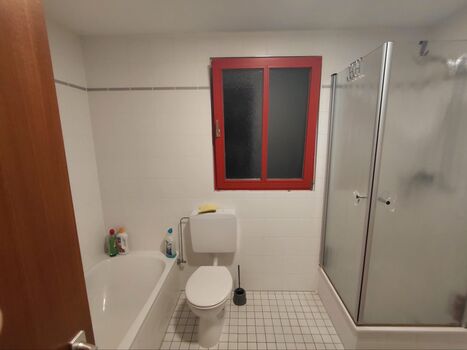 Badezimmer mit Dusche und Badewanne und WC
