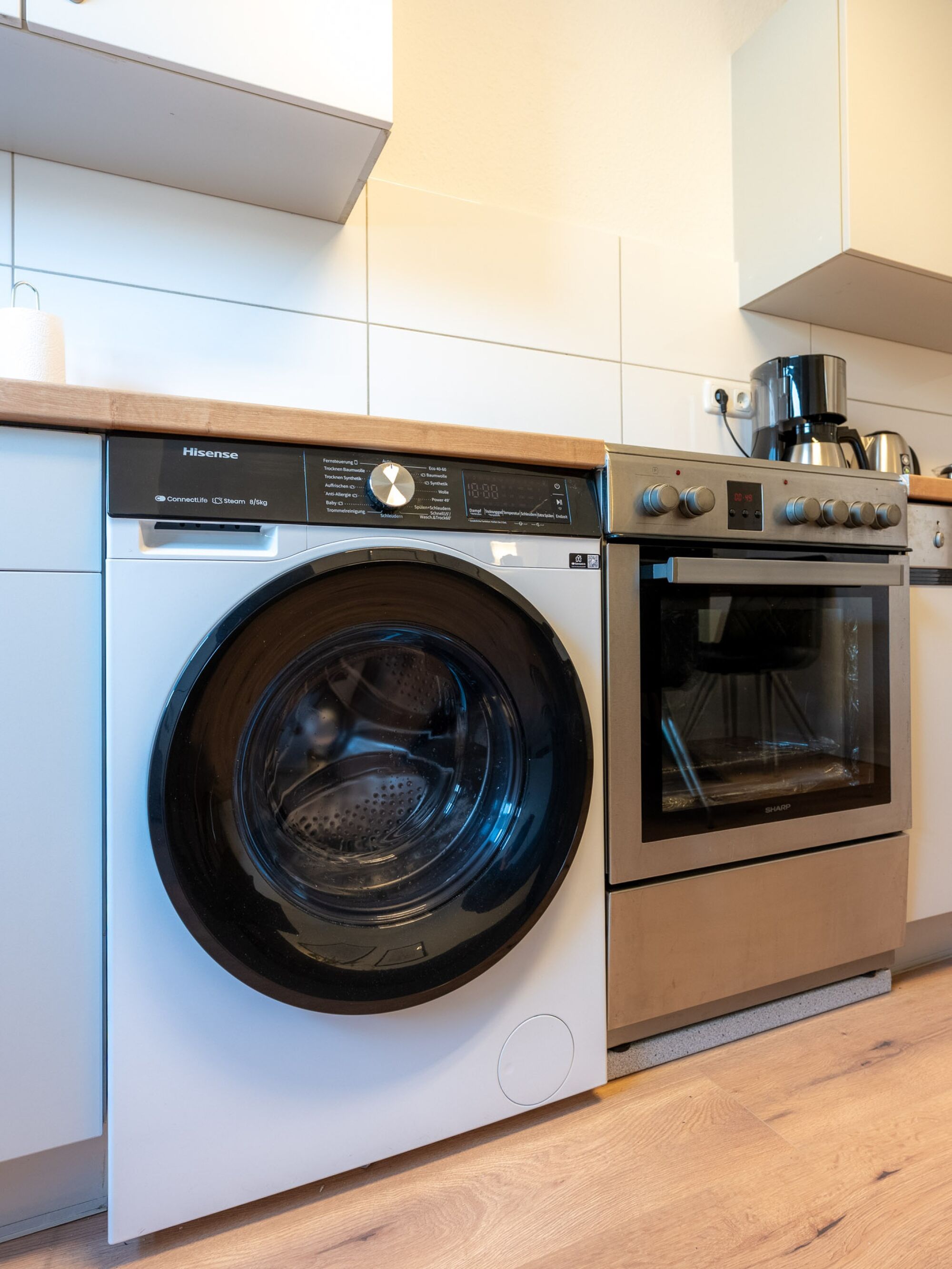 Küche mit Waschtrockner-Kombination, Spülmaschine, Herd (inkl. Pflanzenöl) mit Backofen, Kaffeemaschine (inkl. Kaffeepulver) und Wasserkocher (inkl. div. Teesorten)