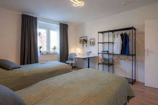 Schlafzimmer 1 mit zwei getrennten Betten (optional), Garderobe und Schreibtisch