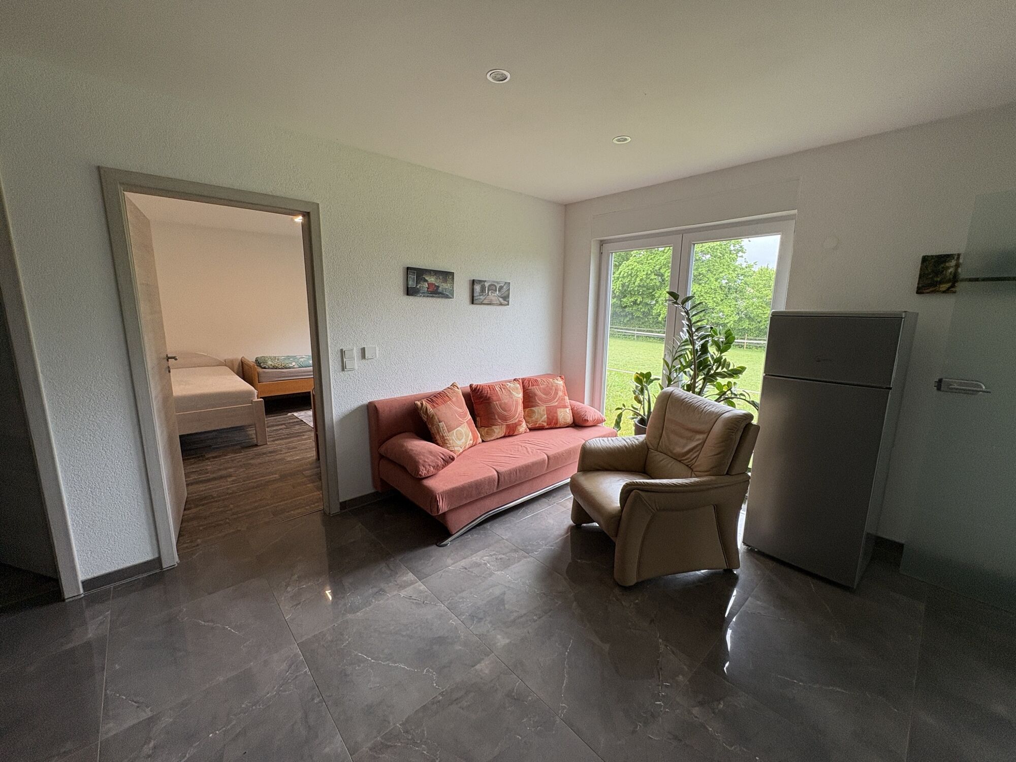 Wohnung 1: Wohnbereich mit Schlafcouch und Terrassentür