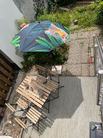 Blick und Weg in den eingezäunten Garten mit Terrassenecke
