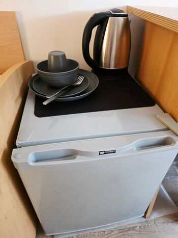 In jedem Zimmer befindet sich ein kleiner Kühlschrank Wasserkocher und Geschirr auch Tassen und Besteck stellen wir ihn gerne zur Verfügung.