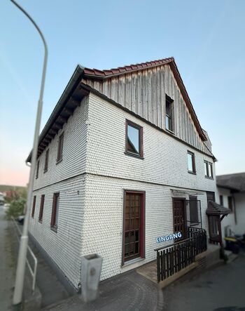 Der Eingang ist auf der rechten Seite des Gebäudes, dort wo das Geländer ist. Geöffnet wird die Türe über einen Schlüssel aus der Schlüsselbox.