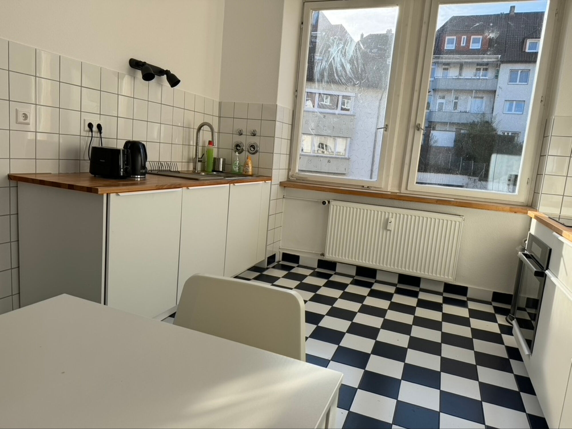 Küche mit Esstisch, großen Kühl-/Gefirerschrank, Spülmaschine, Backofen, Herd, Mikrowelle