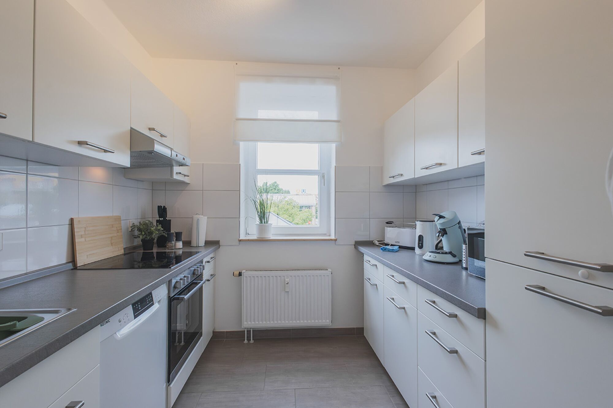 Die moderne Einbauküche ist komplett ausgestattet und hat einen Geschirrspüler, Kühl- Gefrierkombi, eine Mikrowelle, eine Kaffeepad Maschine, Wasserkocher, Sandwichtoaster und einen Toaster