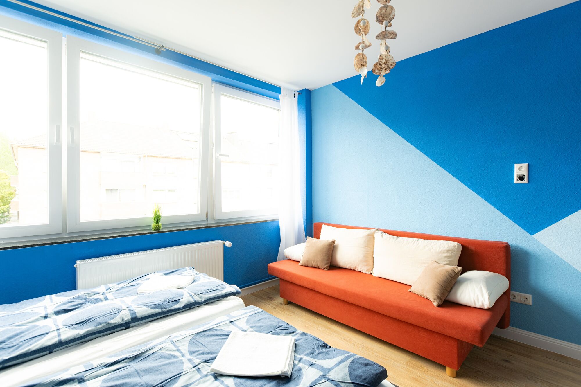 Modernes Doppelbett mit hochwertiger Bettwäsche und gemütlichen Kissen direkt am Fenster. #Schlafkomfort #DuisburgErleben #HellesZimmer #StilvollÜbernachten