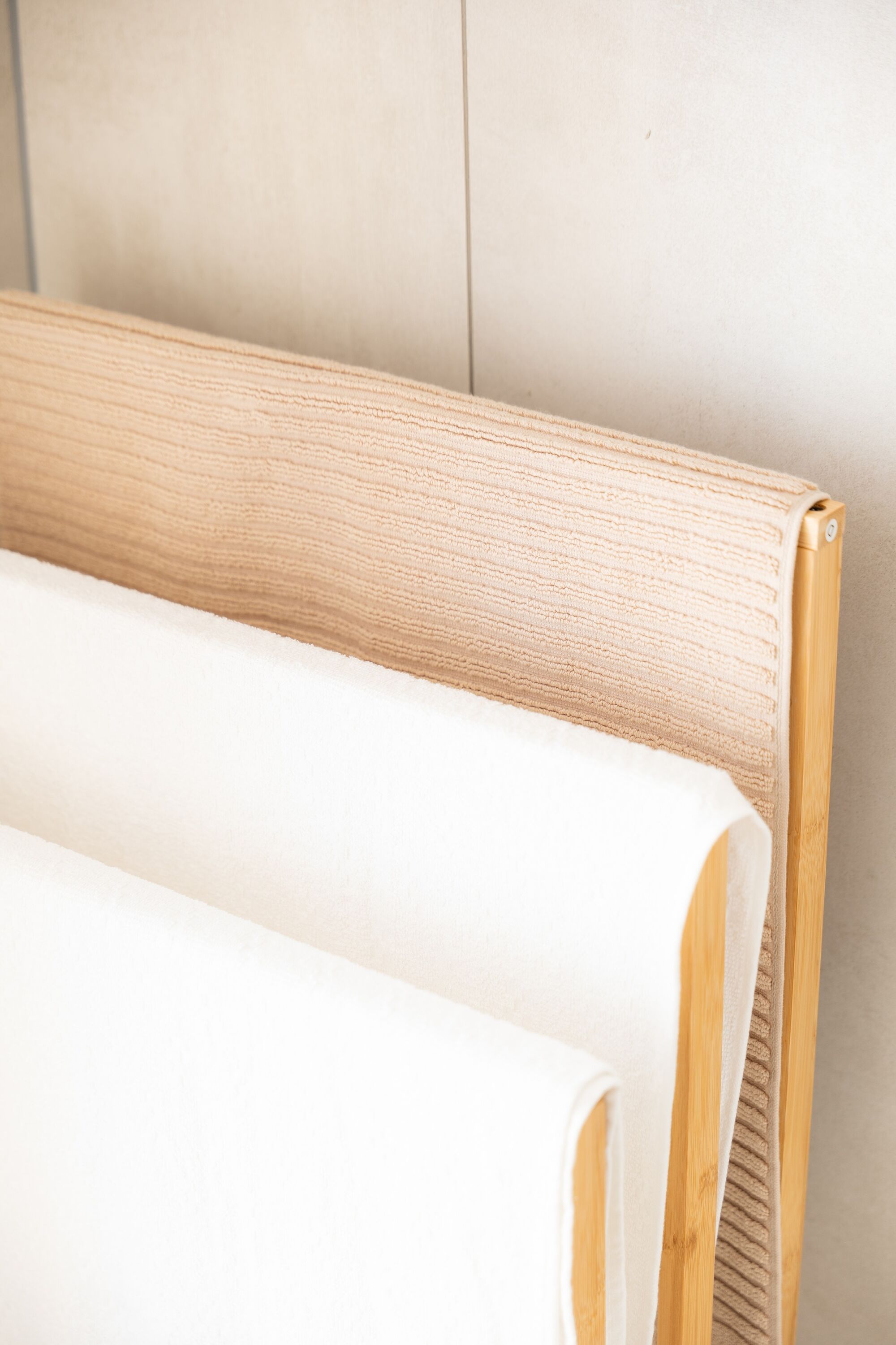 Saubere, weiche Handtücher ordentlich auf einem Holzständer – sofort griffbereit für unsere Gäste. #GästeKomfort #Sauberkeit #VonVImmoServiceUG #VollAusgestattet
