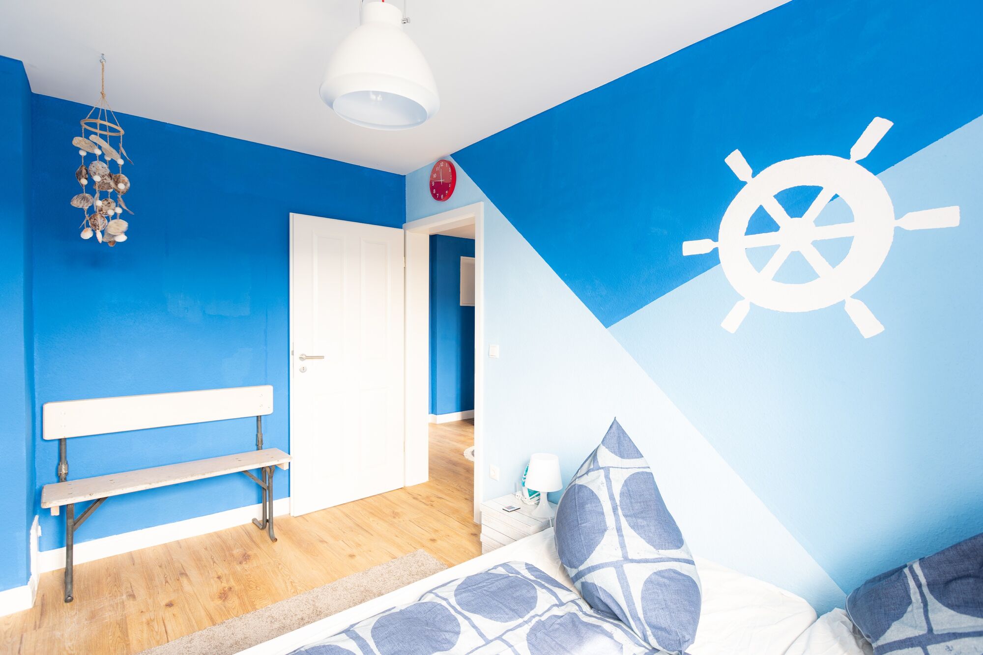 Maritimes Design trifft auf Komfort – stilvolles Schlafzimmer mit klaren Farben und gemütlichem Bett für erholsamen Schlaf. #Schlafkomfort #BlauesDesign #ErholenInDuisburg #VonVImmoServiceUG #ZimmerMitStil