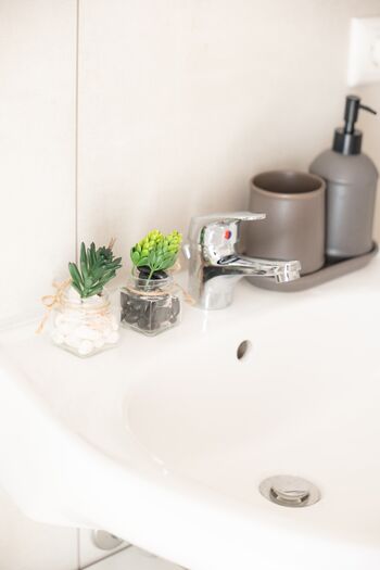 Kleine Dekogläser mit Kunstpflanzen bringen stilvolle Frische ins Bad – für ein angenehmes Ambiente. #ModernesDesign #WohlfühlBad #VonVImmoServiceUG #VollAusgestattet