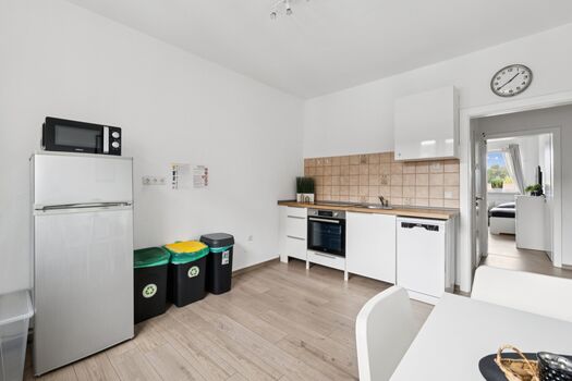 Voll ausgestattete Küche mit Spülmaschine, großem Kühlschrank und gemütlichem Sitzbereich.