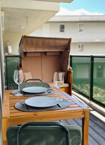 Terrasse mit Esstisch und Strandkorb