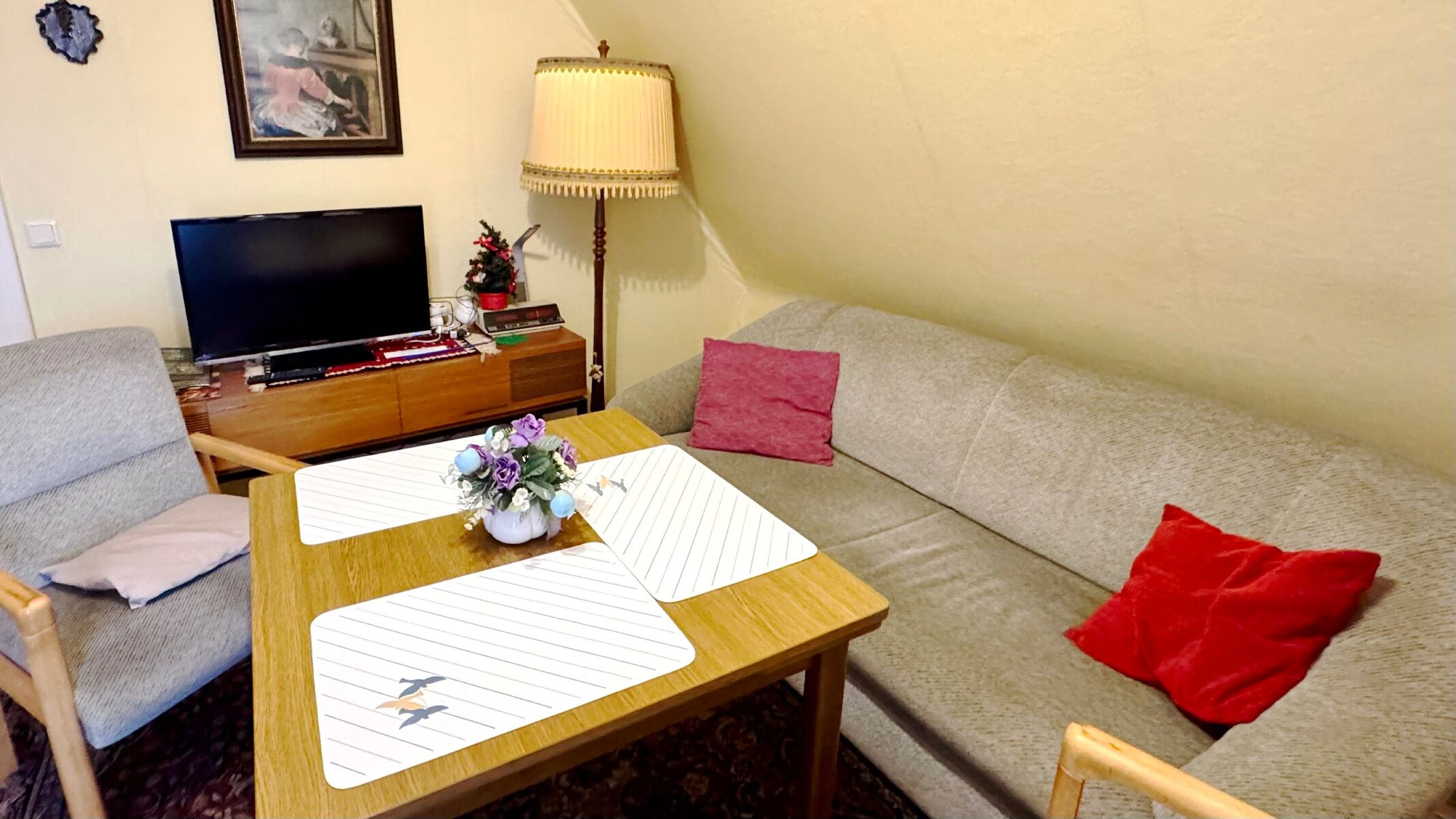 Wohnzimmer mit Esstisch, Sofa und TV