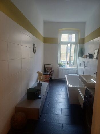 Badezimmer mit Dusche, Wanne und Waschmaschine 