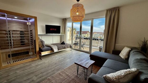 🛋️ Wohnbereich mit Schlafcouch und Sauna