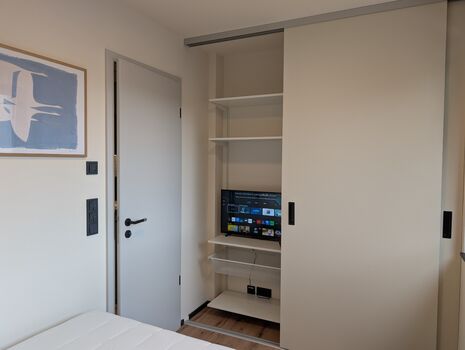 Schlafzimmer mit Schrank und Smart-TV