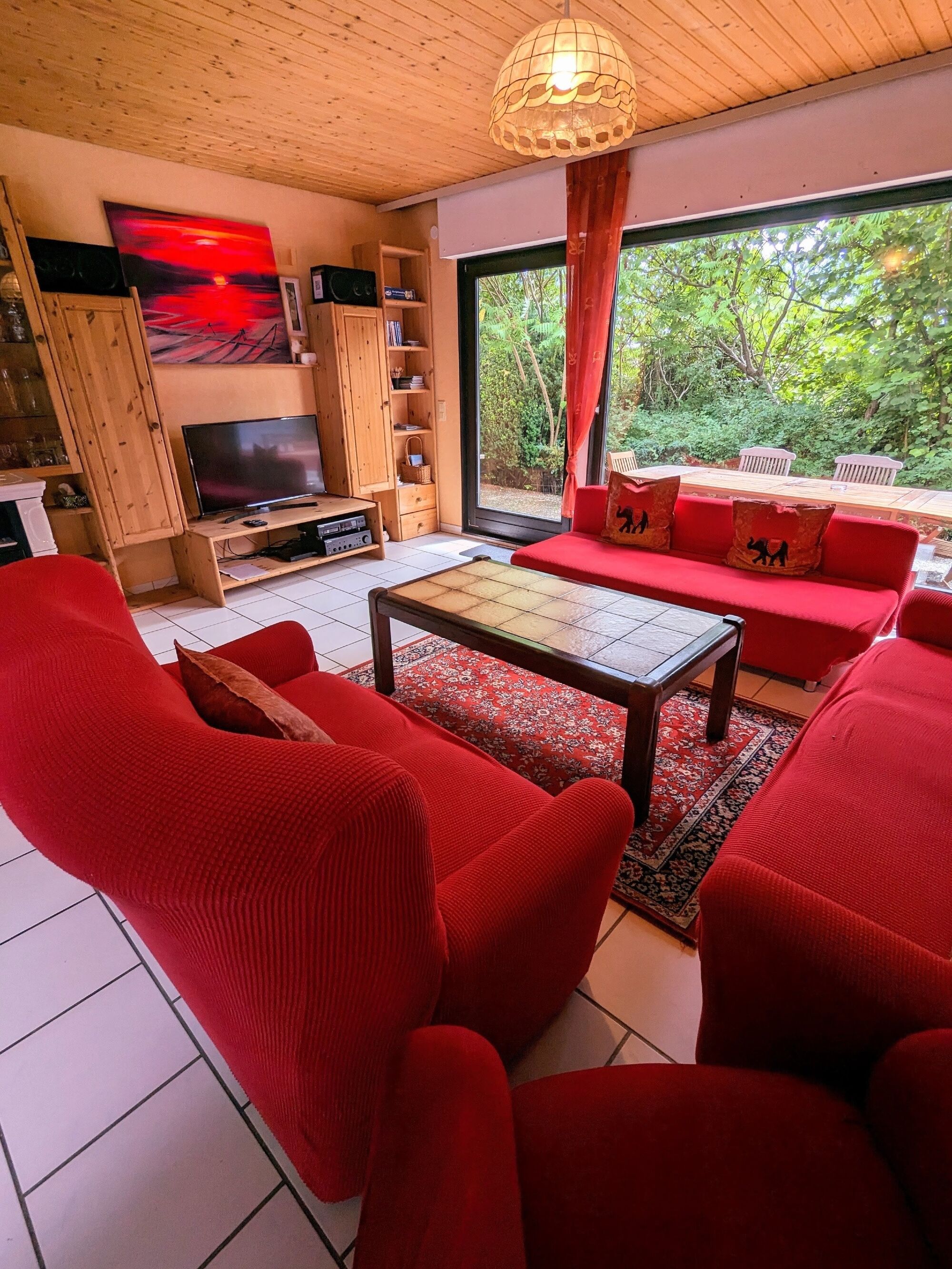 Großes Wohnzimmer mit mehreren Sitzmöglichkeiten und Blick auf die Terrasse 