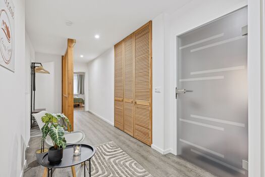 Flur mit Sitzbereich, Garderobe sowie Einbauschrank und Blick auf die Wohnungtür