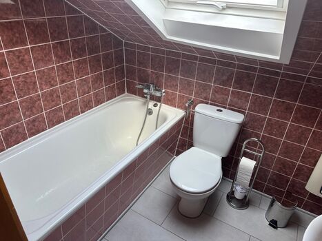 Kompaktes, voll ausgestattetes Badezimmer mit Badewanne und Duschmöglichkeit. Aufgrund der Dachschräge ist die Stehhöhe beim Duschen für sehr große Personen eingeschränkt.