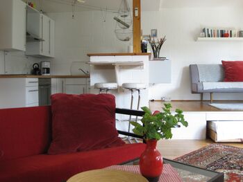 Blick von der gemütlichen Sitzecke auf die Küche und den Schlafbereich der Ferienwohnung