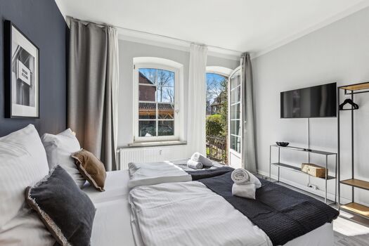 Ein Schlafzimmer bietet direkten Zugang zum Garten und dient gleichzeitig als Raucherbereich – komfortabel und wettergeschützt.