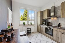 Voll ausgestattete Küche mit großen Töpfen, Mikrowelle, Backofen, Filterkaffeemaschine und Nespresso – ideal zum Kochen wie zuhause.