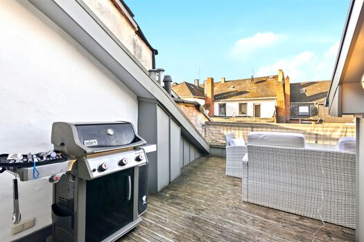Holzdielen-Dachterrasse mit Weber-Gasgrill, grauem Rattan-Loungesofa, Blick über Saarburger Altstadt