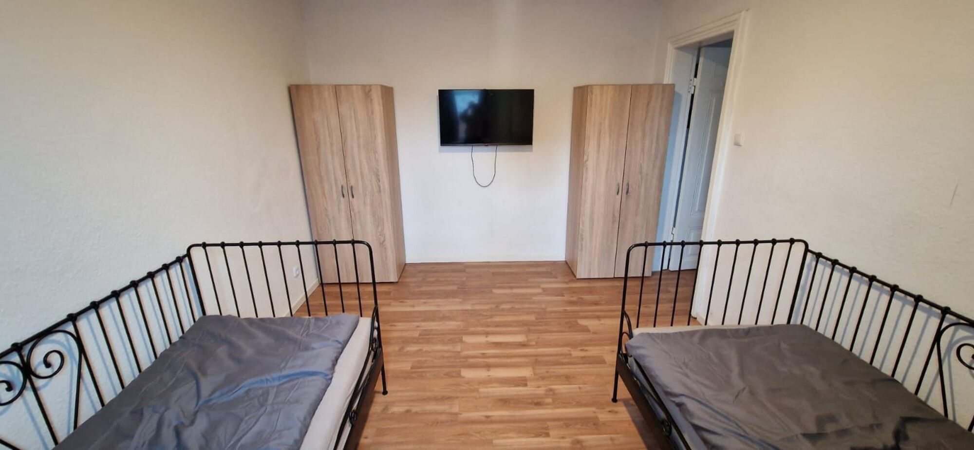 Einzelzimmer mit zwei Betten, TV und Kleiderschrank