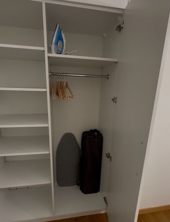 Kleiderschrank, Bügeleisen und Babybett