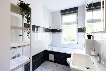 Komfortable Badezimmer mit Dusche, Pflegeartikeln und Stauraum.