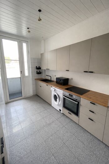 Moderne Küche mitt Mikrowelle, zwei großen Kühlschränken, Mikrowelle und Spülmaschine