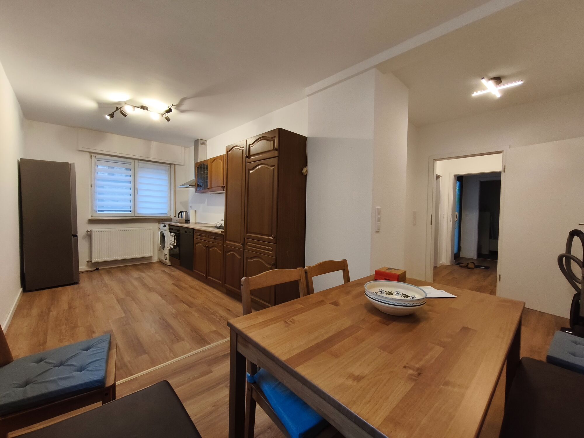 EG - große, komplett ausgestattete Küche mit großem Kühlschrank, Waschmaschine und gemütlicher Sitzecke - Blick von Sitzecke auf Küchenzeile und Eingang/Flur