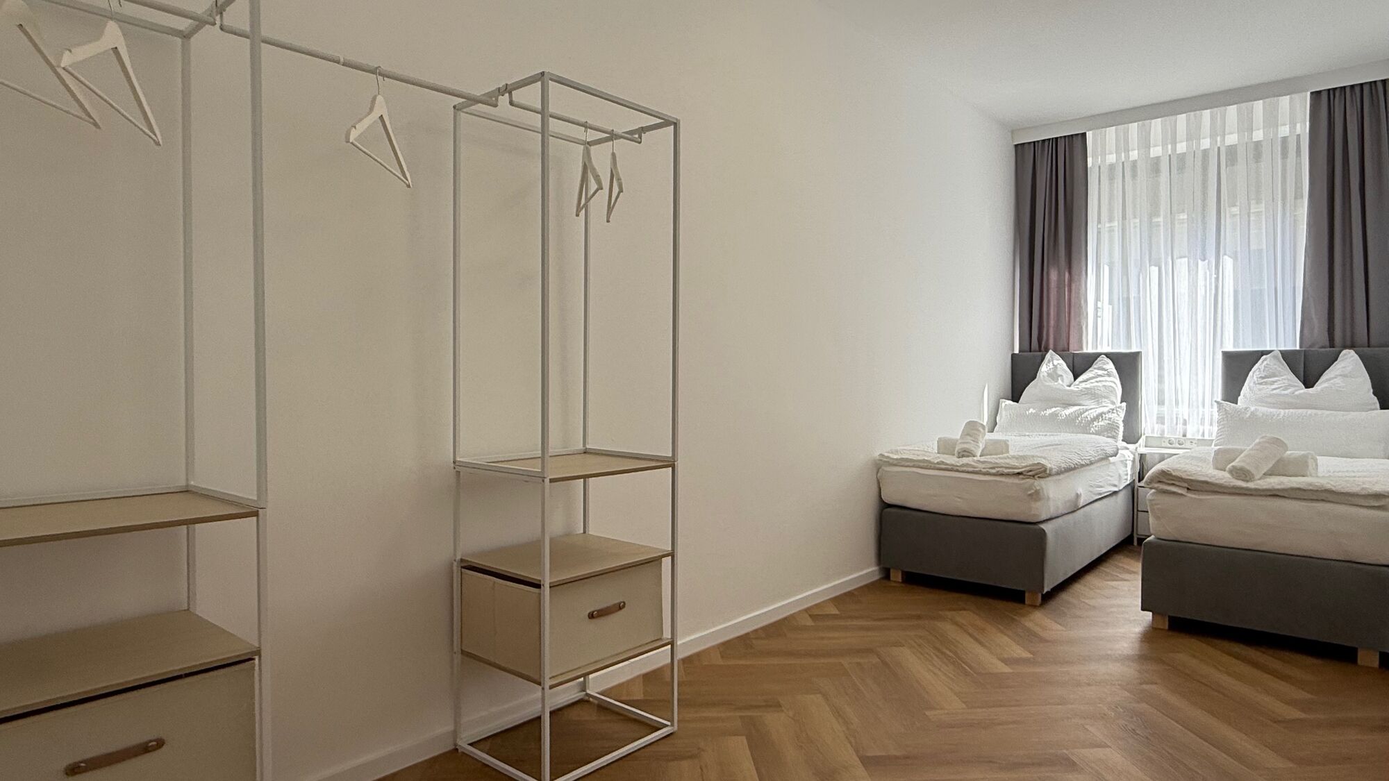Helles Schlafzimmer mit zwei gemütlichen Einzelbetten, die sich im Handumdrehen zu einem großzügigen Queensize-Bett kombinieren lassen. Viel Platz und verdunkelnde Gardinen sorgen für kuschelige, entspannte Nächte und erholsamen Schlaf.