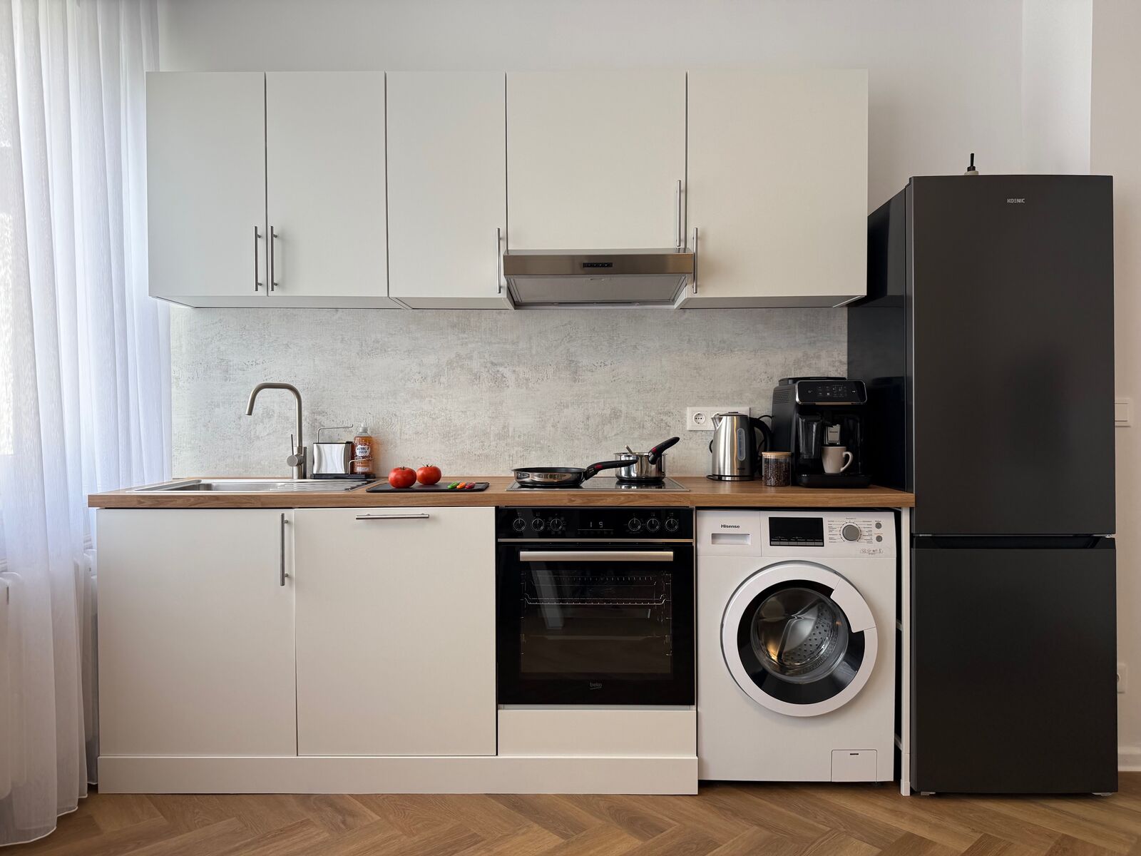 Praktische Küche mit allem, was du brauchst: großer Kühlschrank, moderner Backofen, Kochfeld, Kaffeemaschine und Waschmaschine. Hier gelingt jedes Gericht mühelos - ideal für Selbstversorger und entspannte Abende nach einem Tag in Kiel.
