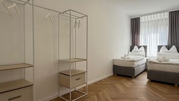 Helles Schlafzimmer mit zwei gemütlichen Einzelbetten, die sich im Handumdrehen zu einem großzügigen Queensize-Bett kombinieren lassen. Viel Platz und verdunkelnde Gardinen sorgen für kuschelige, entspannte Nächte und erholsamen Schlaf.