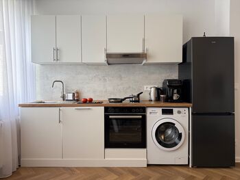 Praktische Küche mit allem, was du brauchst: großer Kühlschrank, moderner Backofen, Kochfeld, Kaffeemaschine und Waschmaschine. Hier gelingt jedes Gericht mühelos - ideal für Selbstversorger und entspannte Abende nach einem Tag in Kiel.