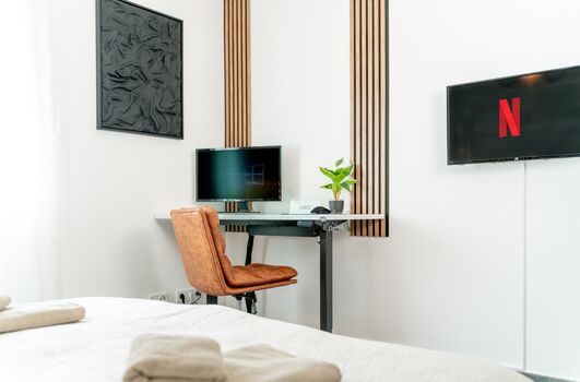 moderner Arbeitsplatz mit elektrisch höhenverstellbaren Arbeitstisch, 4K-28-Zoll Monitor (inkl. aller Anschlusskabel), Maus, sowie einem Smart-TV