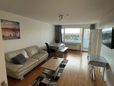 Wohnzimmer einer 6-Personen-Wohnung mit Balkon