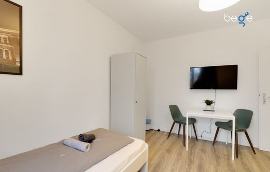 Schlafzimmer 1 mit zwei Einzelbetten, Sitzecke und Smart TV 