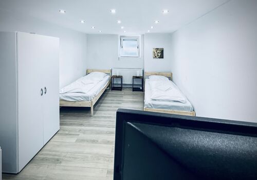 Wohnung 2: Schlafzimmer 1 mit Einzelbetten; Smart TV; Kühlschrank / Apartment 2: Bedroom 1 with single beds; Smart TV; fridge