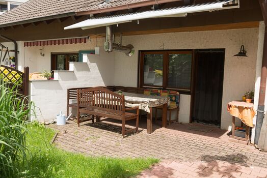 Terasse mit Markise und kleiner Garten