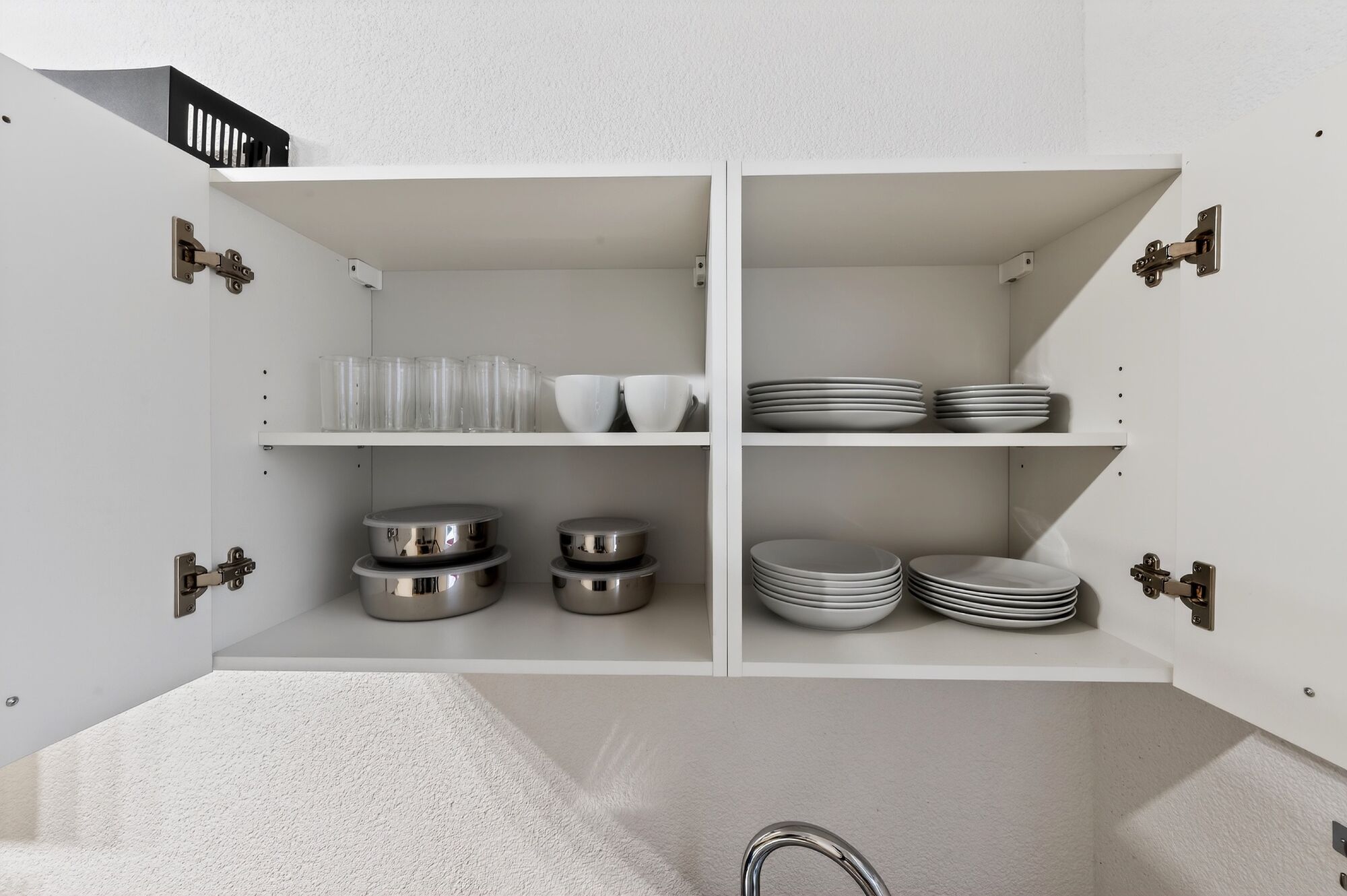 Großer Geschirrschrank mit Tellern, Gläsern und Tassen – ausreichend ausgestattet für Gruppen und gemeinsame Mahlzeiten.