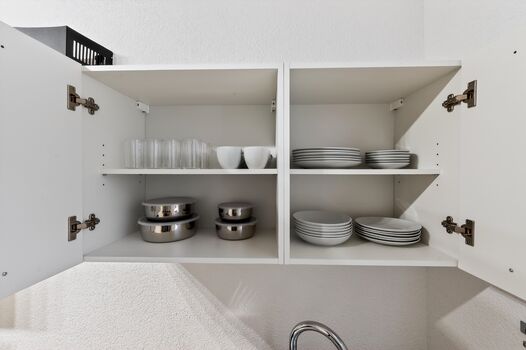 Großer Geschirrschrank mit Tellern, Gläsern und Tassen – ausreichend ausgestattet für Gruppen und gemeinsame Mahlzeiten.