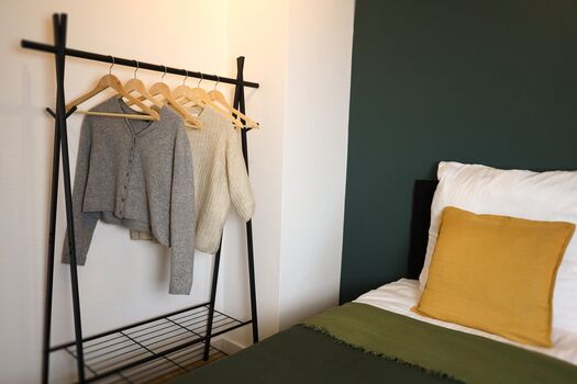 Schlafzimmer 2 - Twin-Schlafzimmer mit zwei Einzelbetten, hochwertiger Bettwäsche, TV, Nachttischlampen und ruhigen Grüntönen.