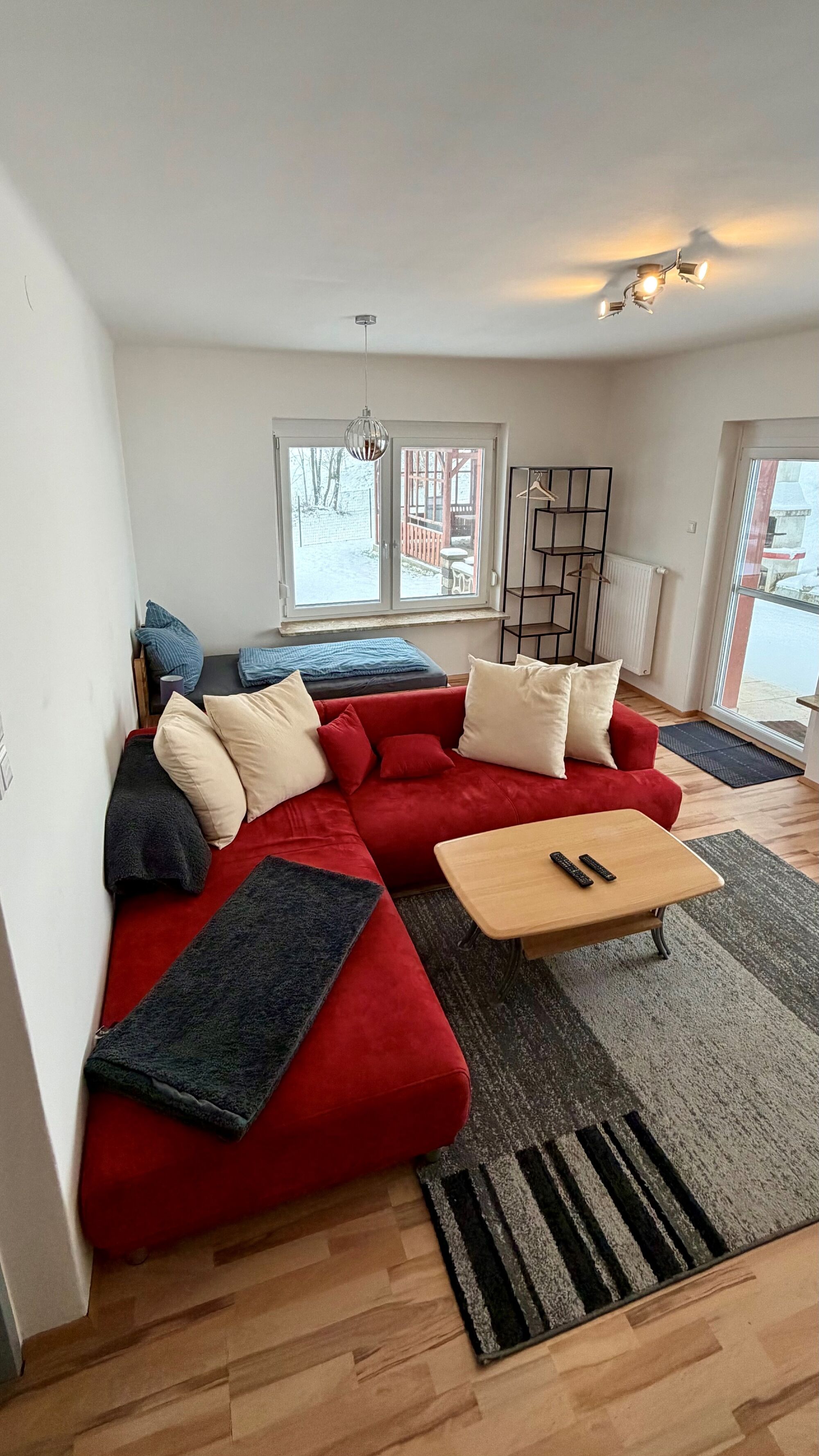 Wohnzimmer mit Einzelbett und Schlafcouch